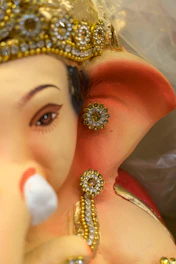 Close-up of a brass goddess Lakshmi statue with intricate detailing on the crown and jewelry.