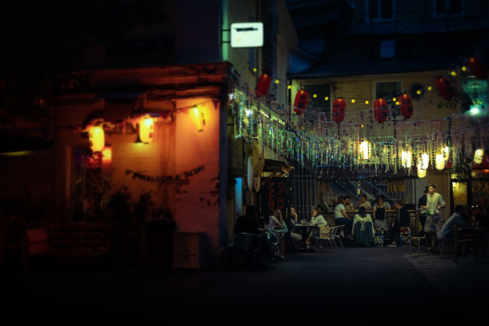 a group of people sitting at a table outside of a building