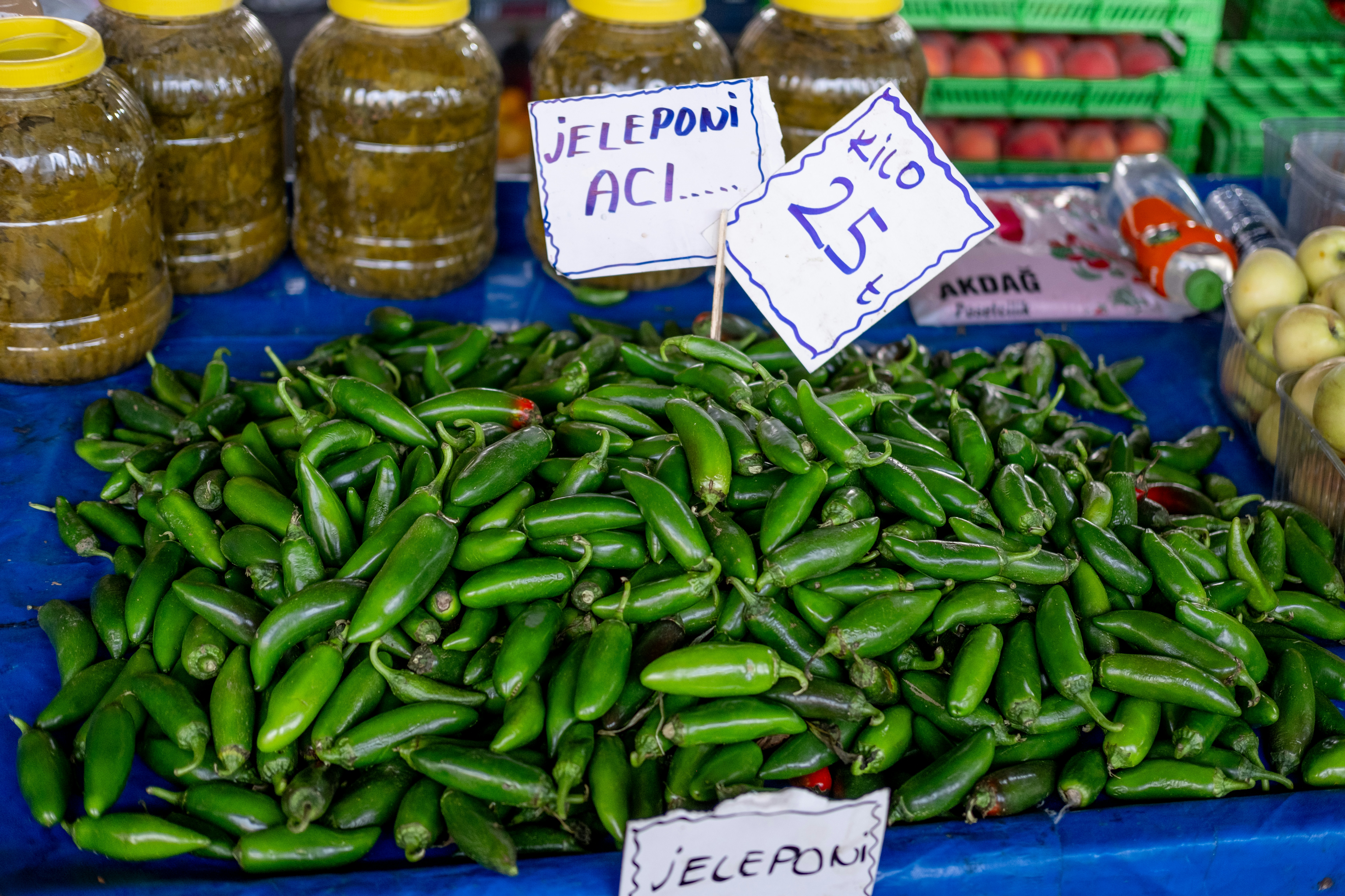 uma pilha de pimentões verdes sentada em cima de uma mesa azul