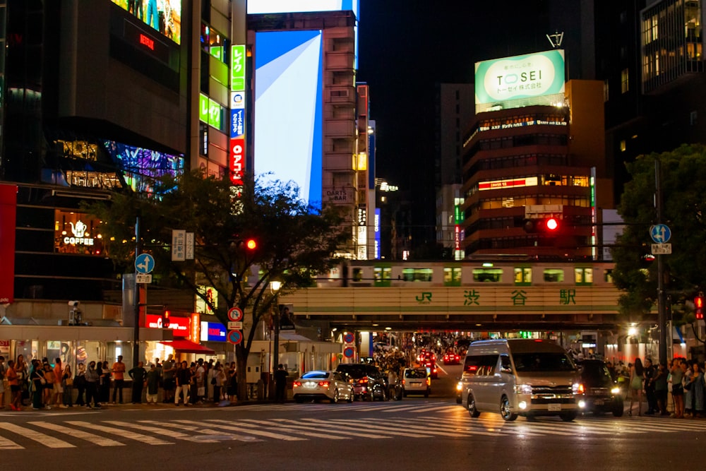 a busy city street at night with cars and people