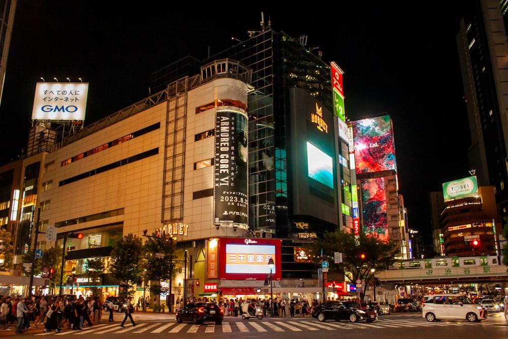 a busy city street at night with people crossing the street