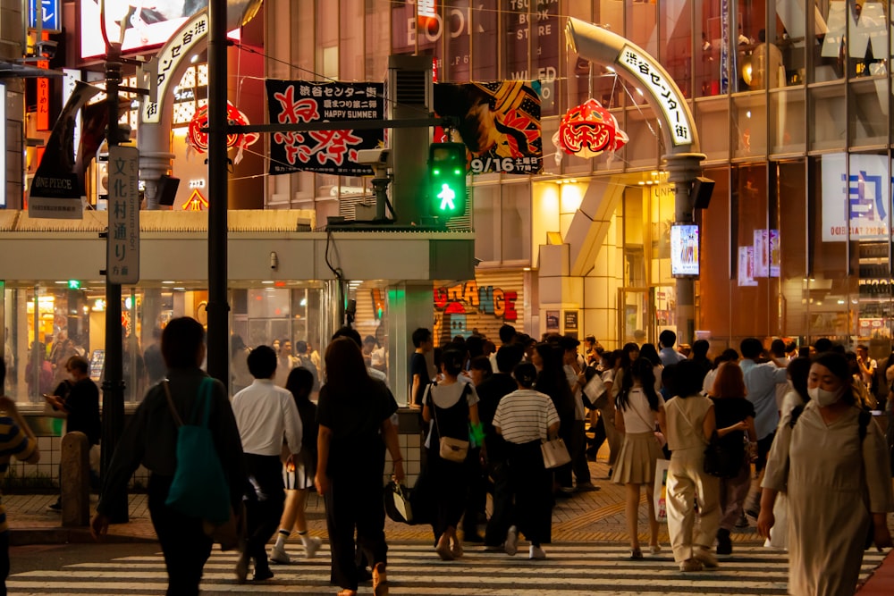 a crowd of people walking across a cross walk