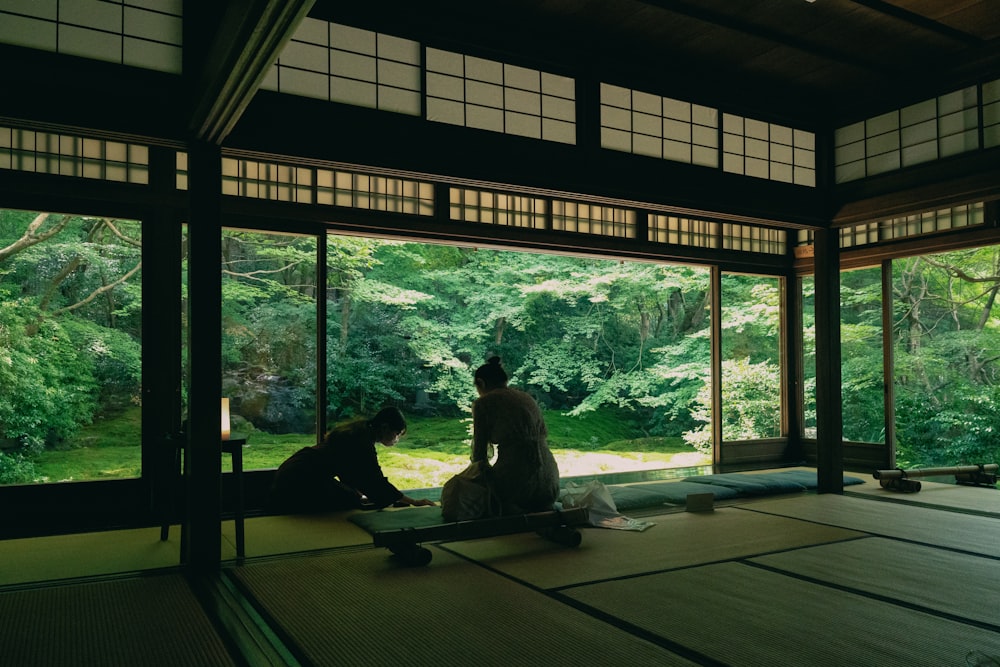 a couple of people sitting on top of a wooden floor