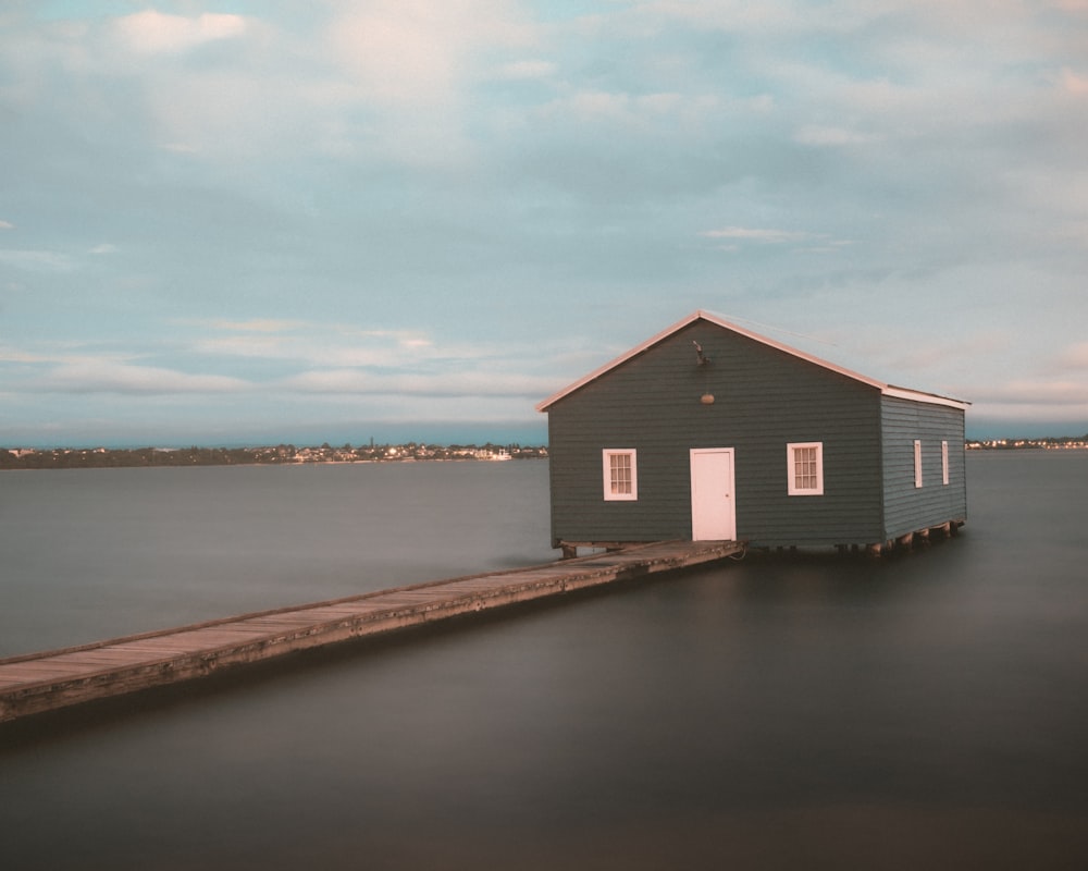 a small house sitting on top of a wooden pier