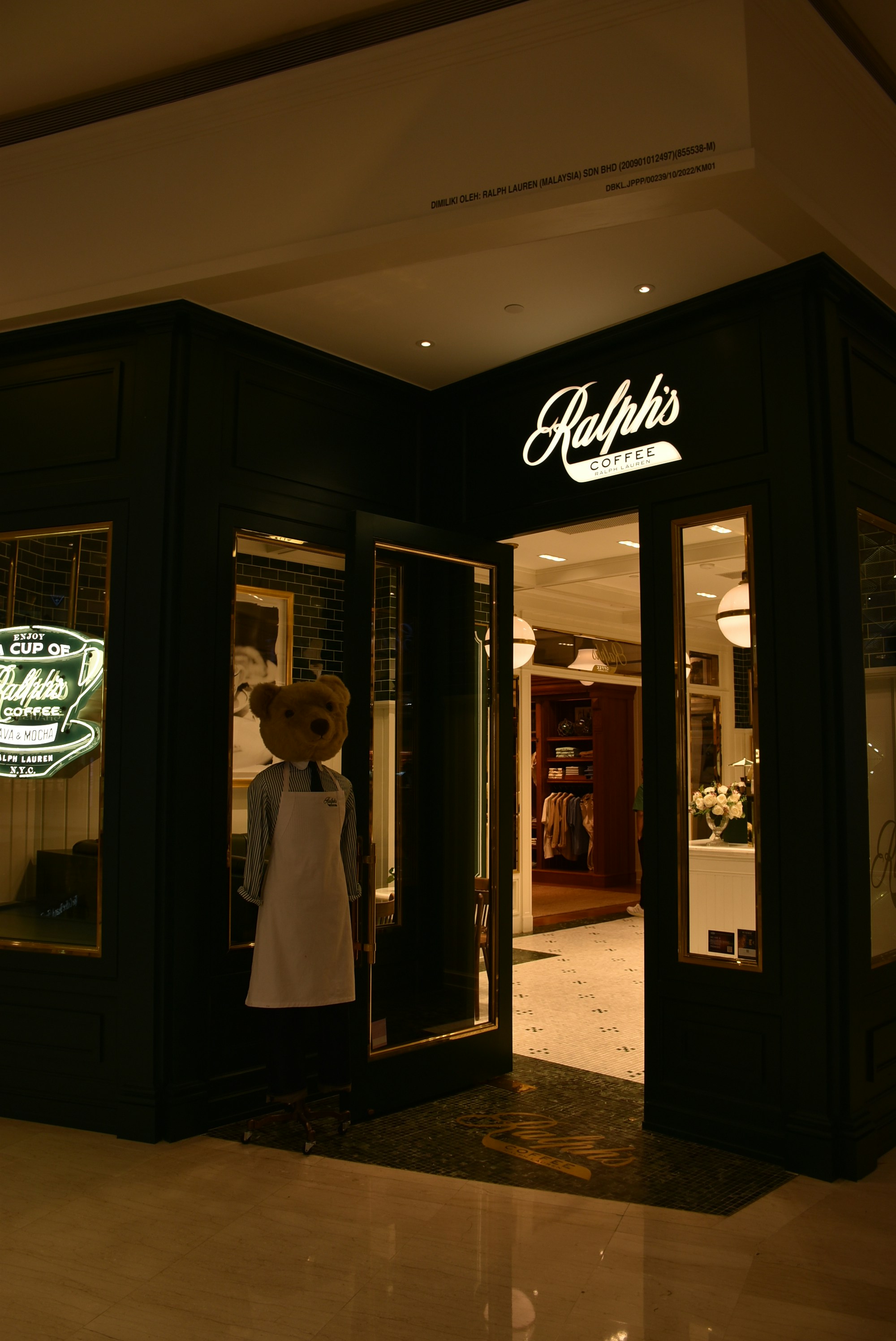 a store front with a teddy bear in the doorway