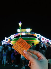 Smiling tourists holding combo tickets with amusement park and zoo in background.