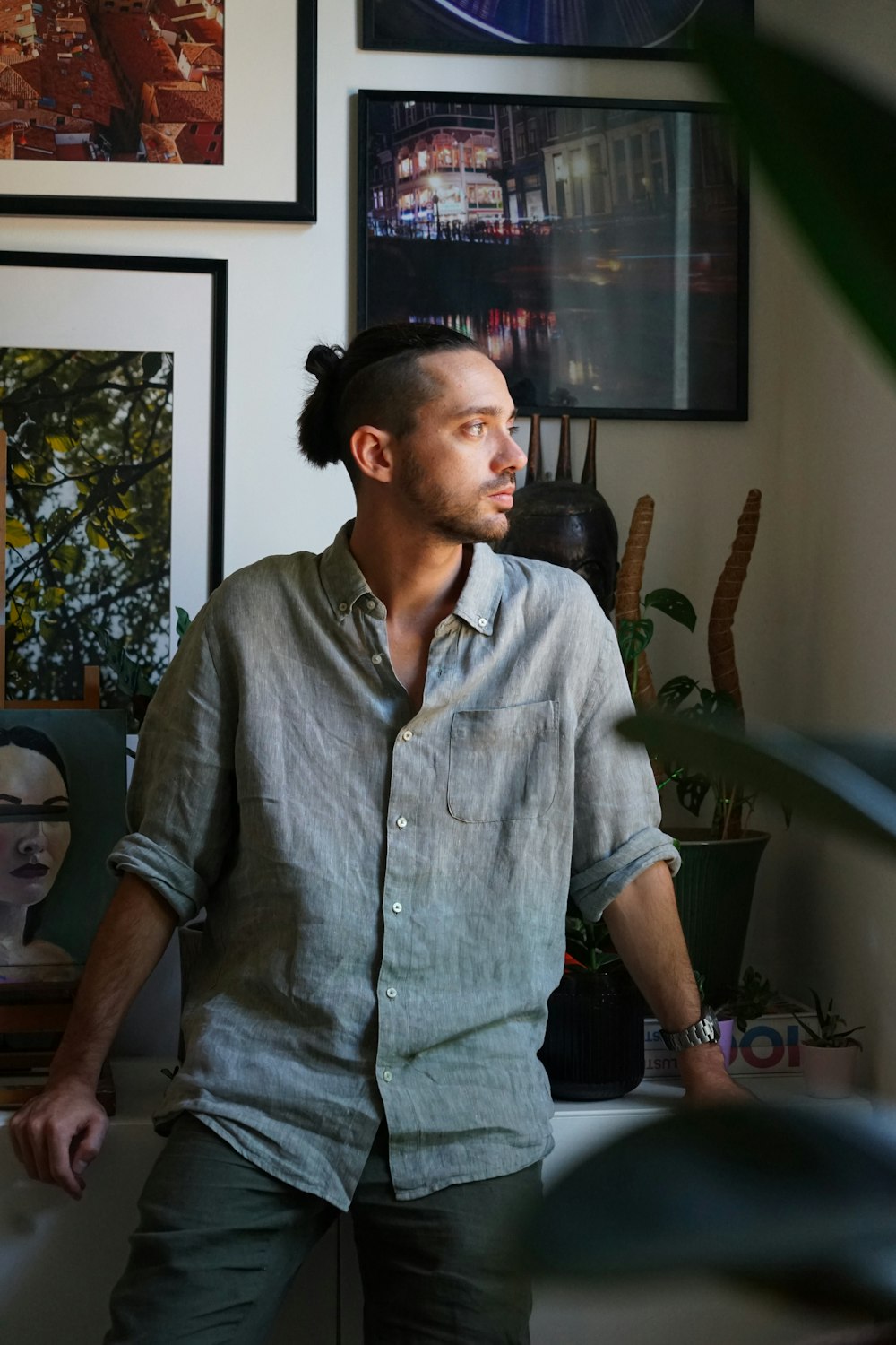 a man standing in a living room next to a plant