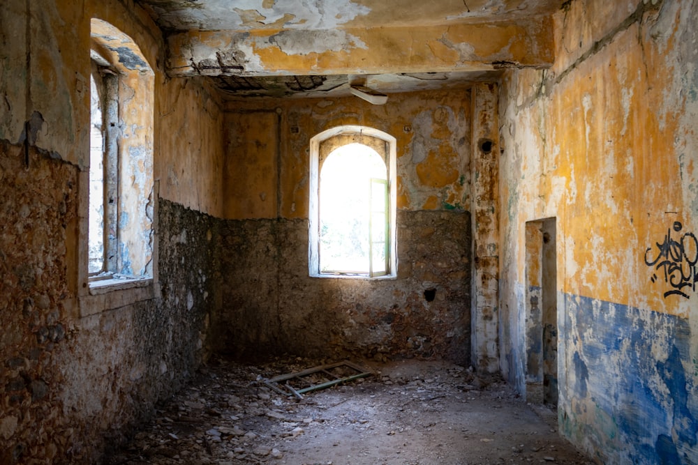 uma sala degradada com pichações nas paredes