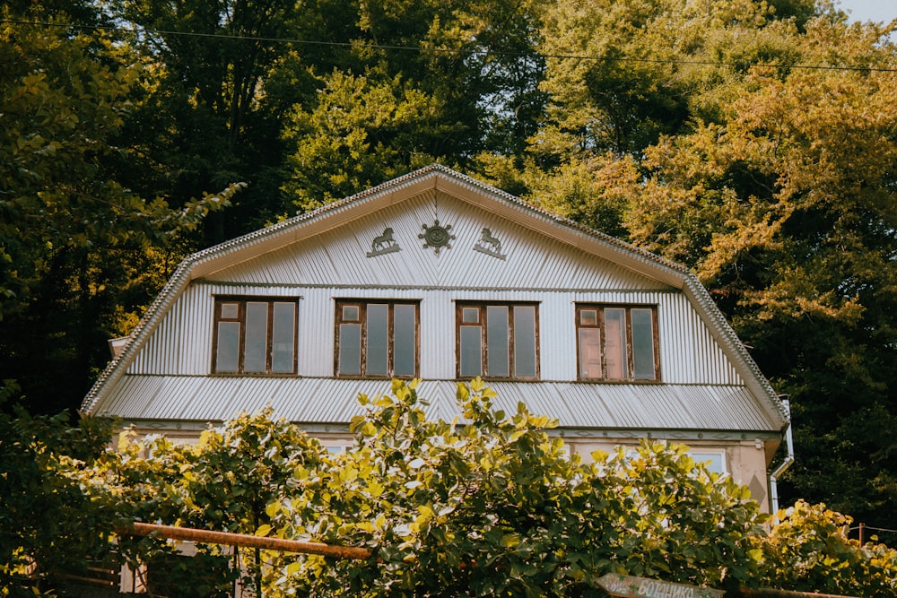 a white house surrounded by trees and bushes