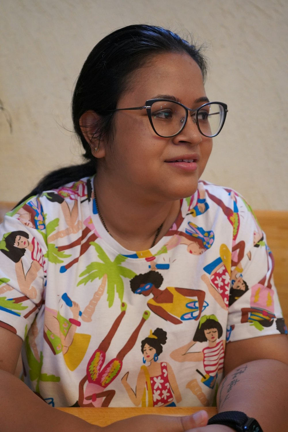 a woman wearing glasses sitting at a table