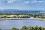 A panoramic view of a large porosity reservoir nestled in a natural landscape, capturing water under a clear sky.