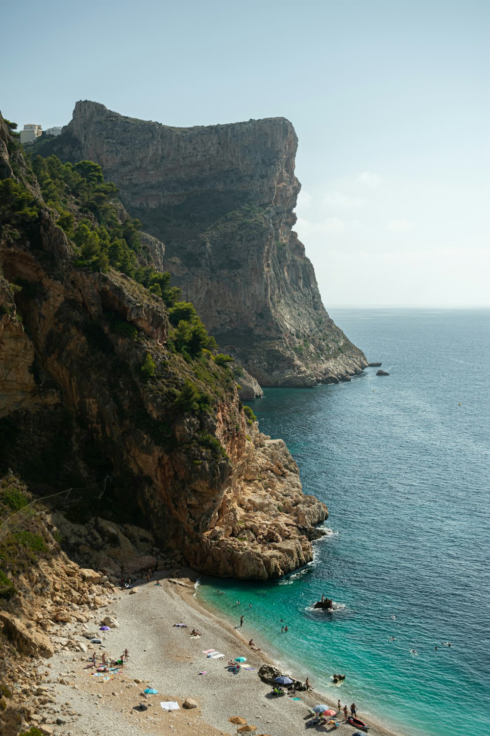 a beach with people laying on it next to the ocean