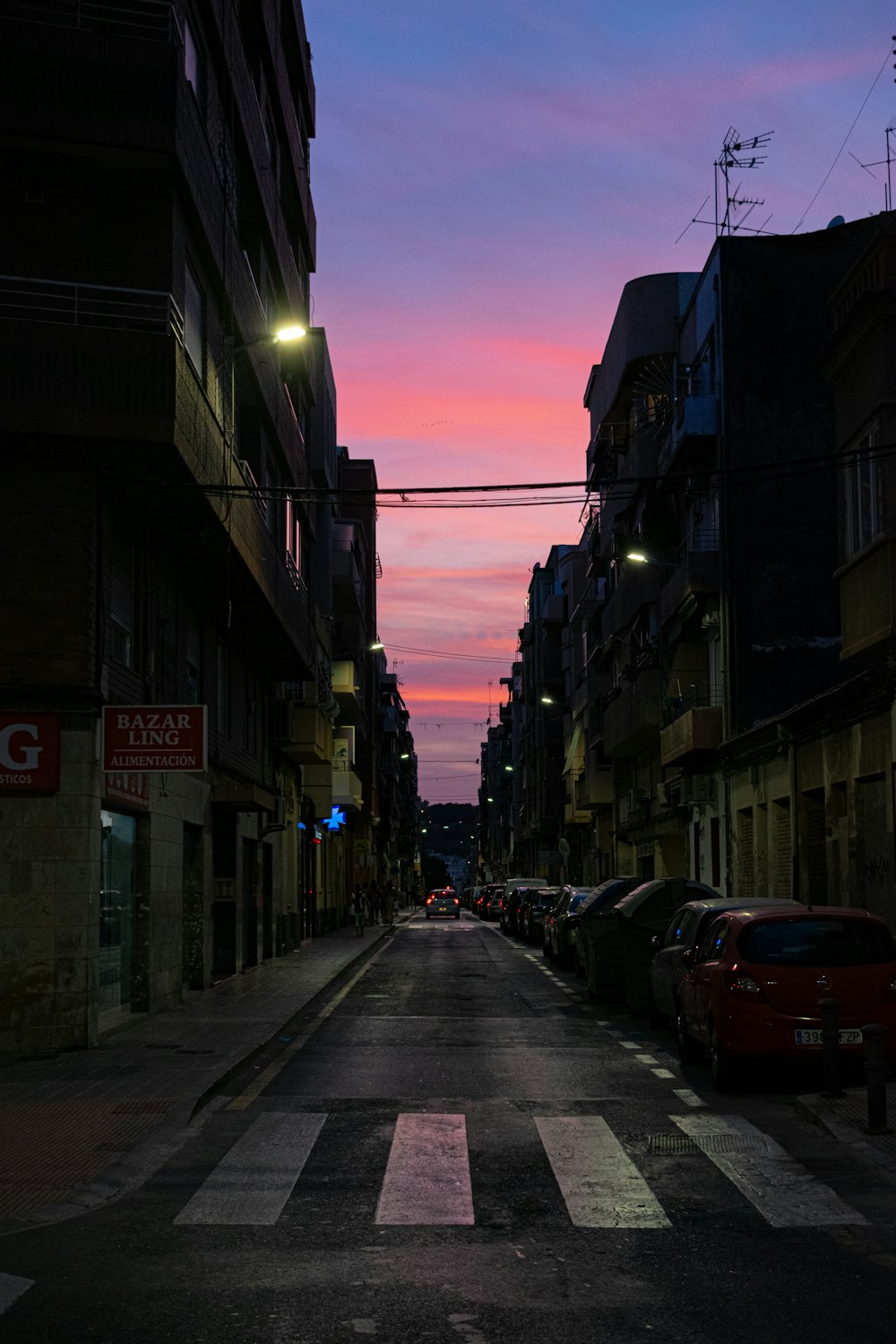 una calle con coches aparcados a ambos lados de la misma