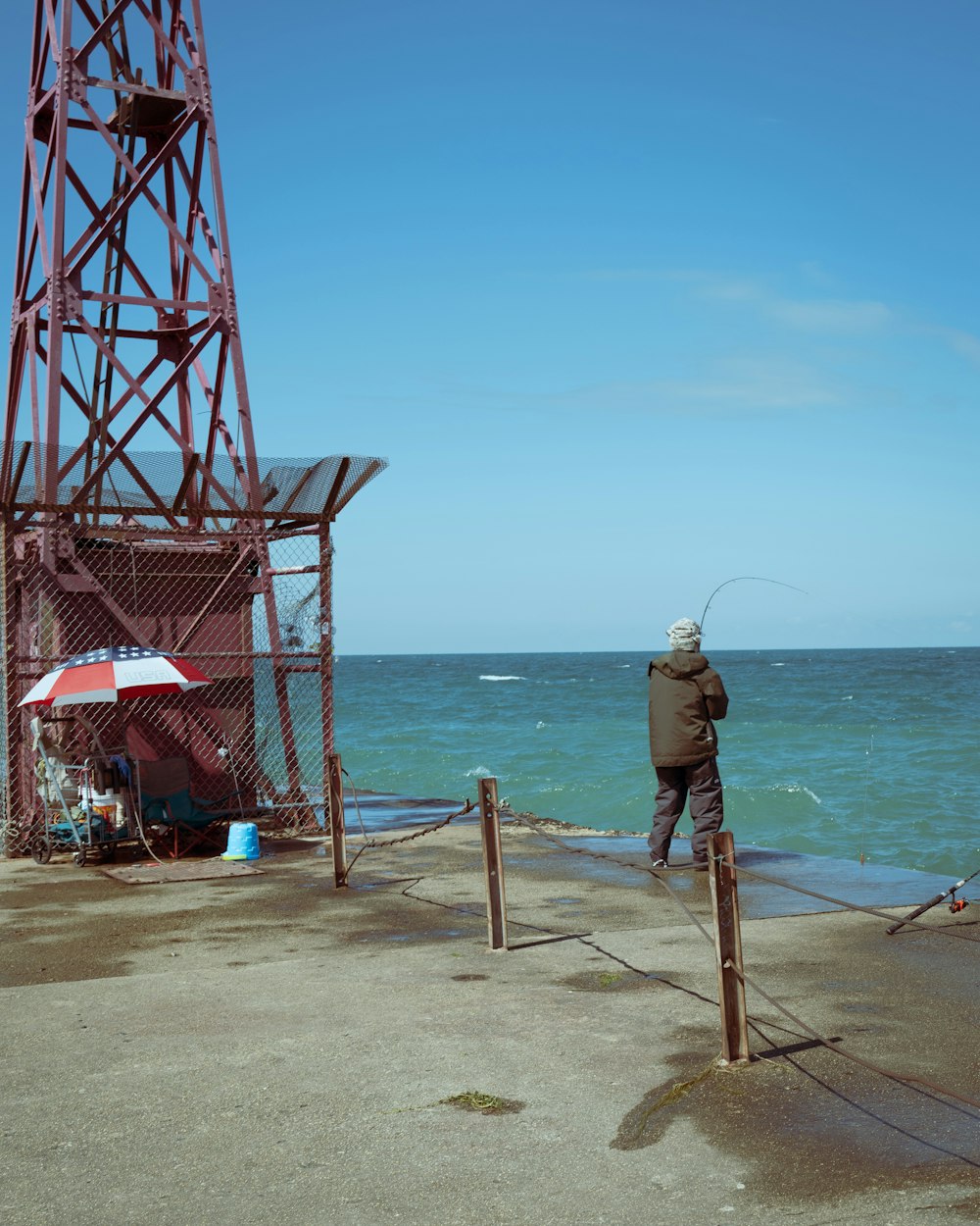 a man standing on top of a pier next to the ocean