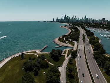an aerial view of a highway near a large body of water