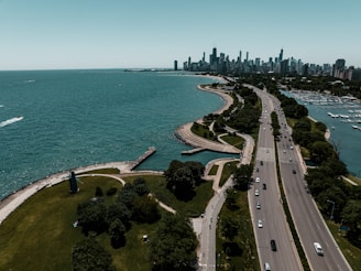 an aerial view of a highway near a large body of water