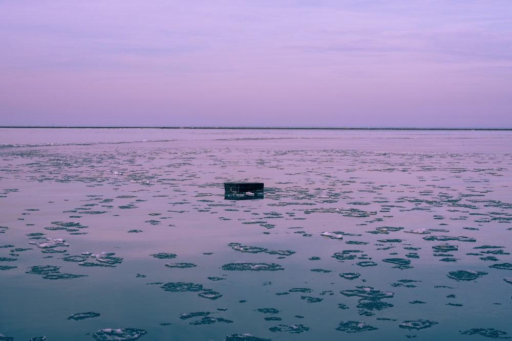 a square object floating in the middle of a body of water