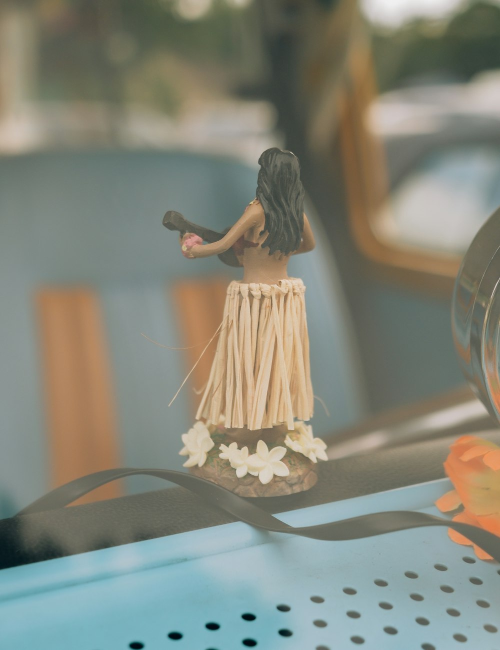 a small figurine of a woman holding a fan