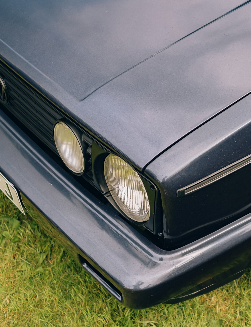 a close up of a car headlight on the grass