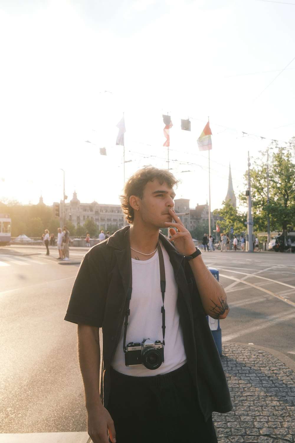 a man standing on the side of a road smoking a cigarette