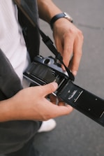 Close-up of hands loading 120 film into a classic medium format camera.