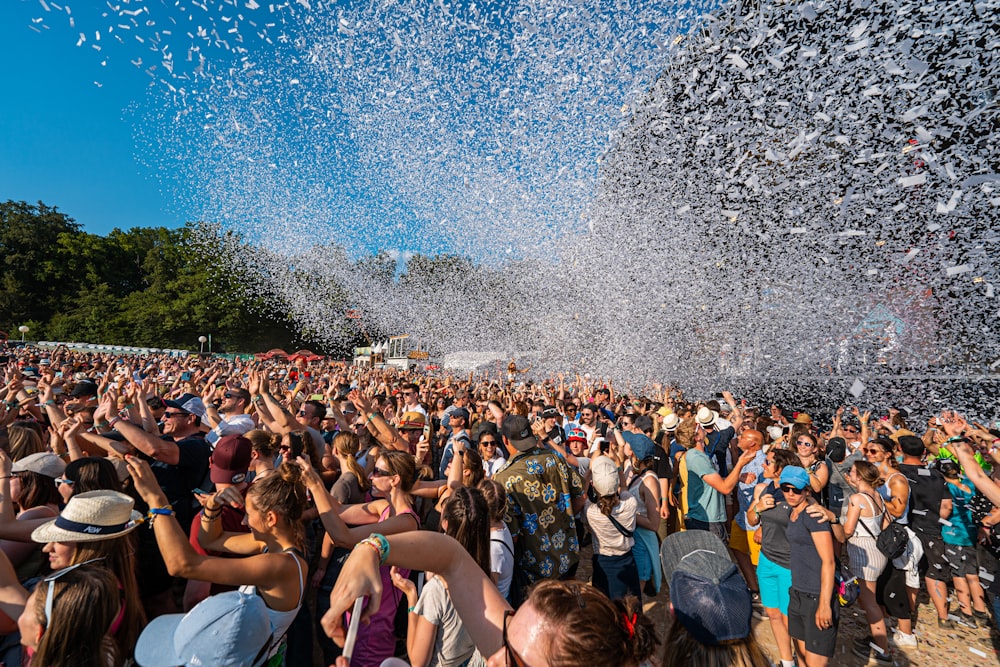 a large group of people are throwing confetti into the air