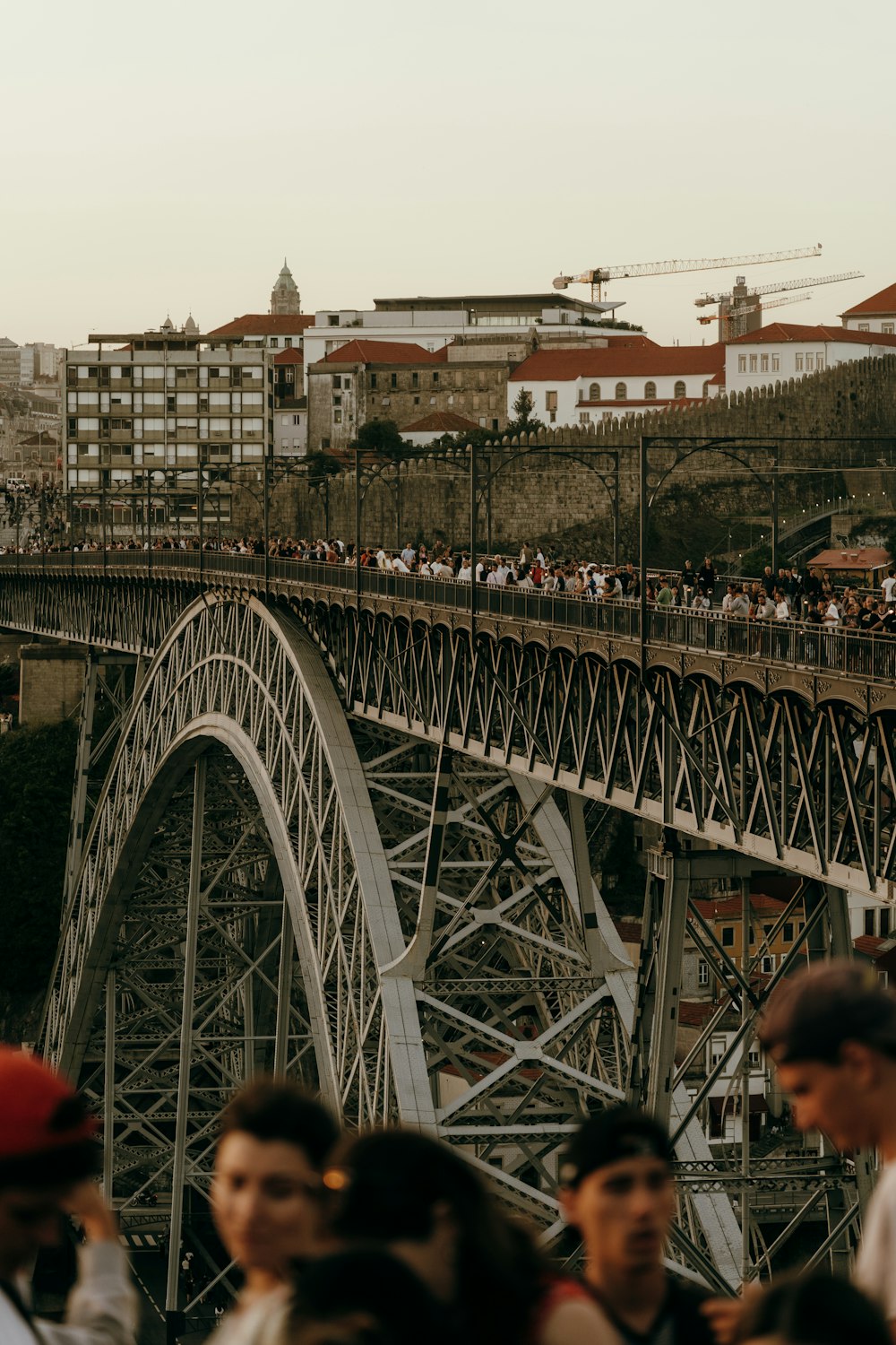 a crowd of people walking across a bridge