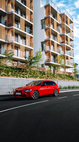 Close-up of hands exchanging keys in front of a modern residential building.