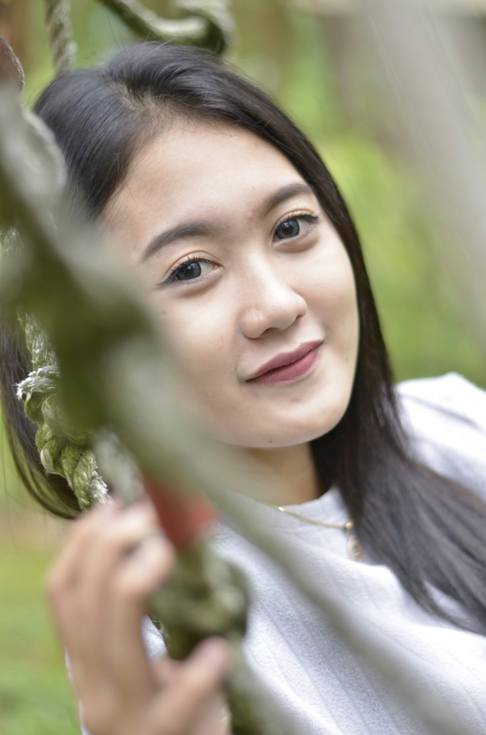 a woman is smiling while holding onto a plant