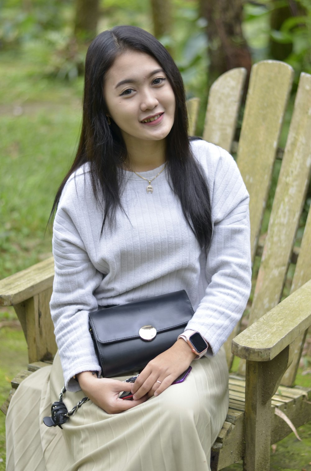 a woman sitting on a bench holding a purse