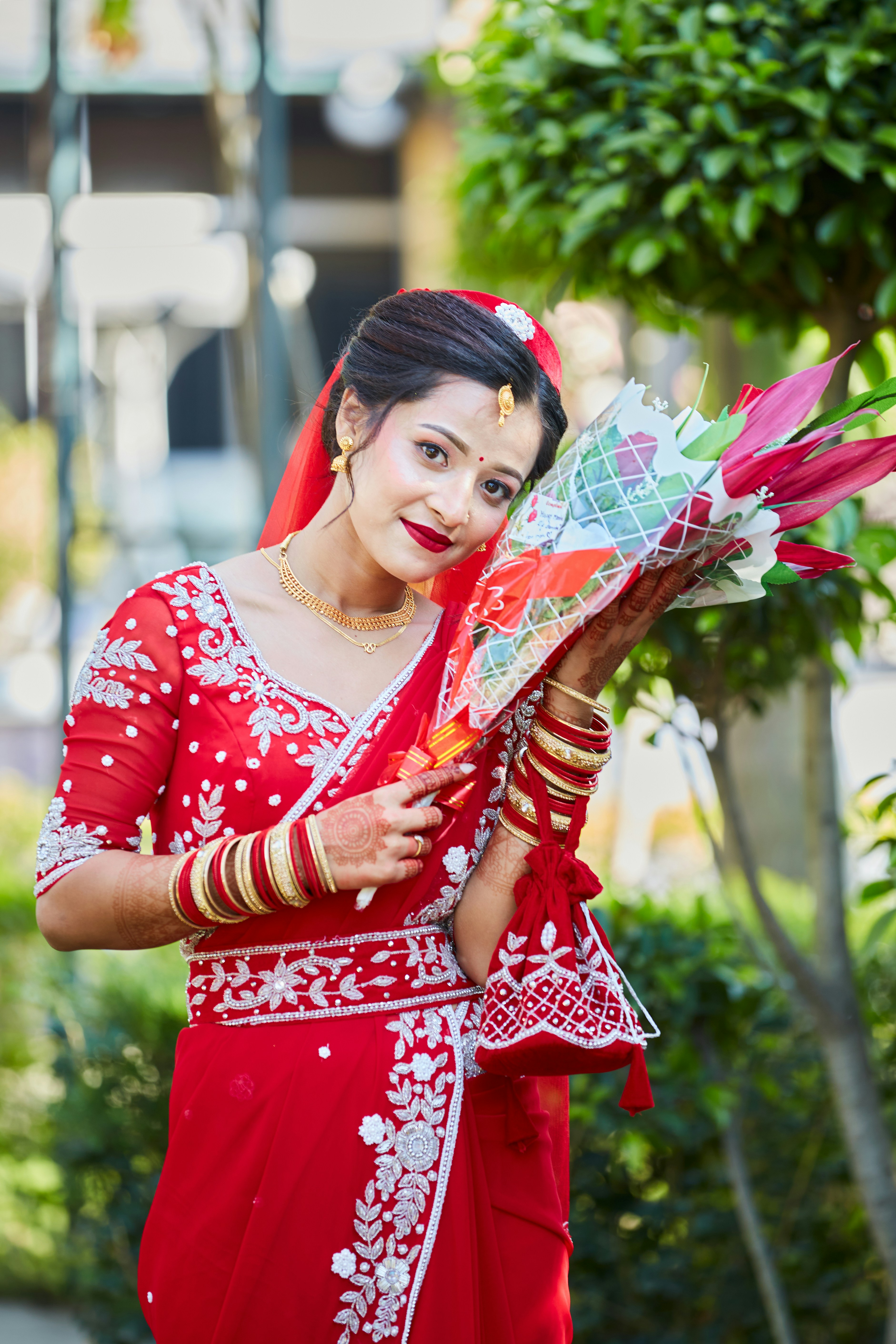 Una mujer con un vestido rojo sosteniendo un ramo de flores