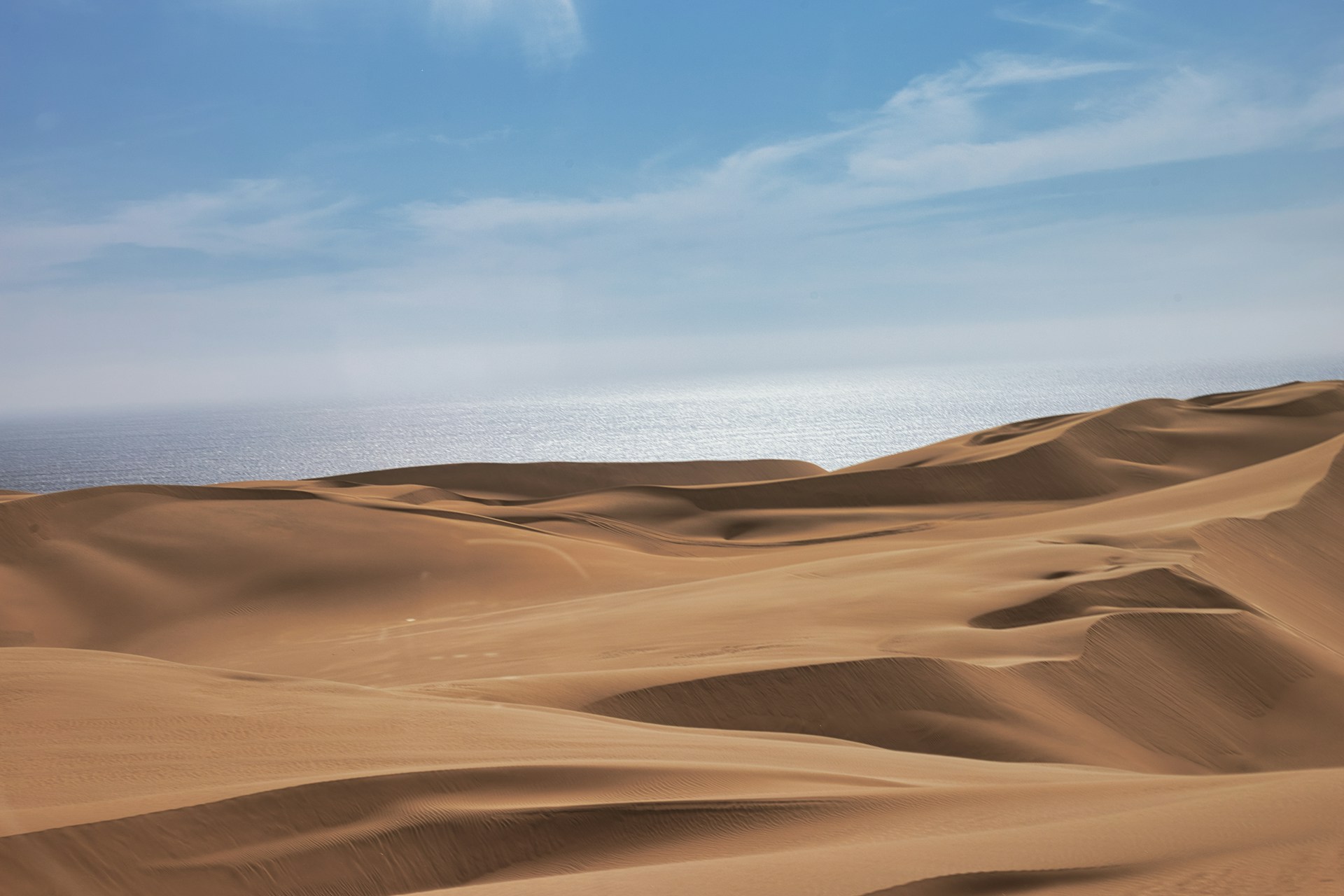 The golden sand dunes of Mambrui stretching under a bright blue sky, inviting adventurers to explore their rolling curves.