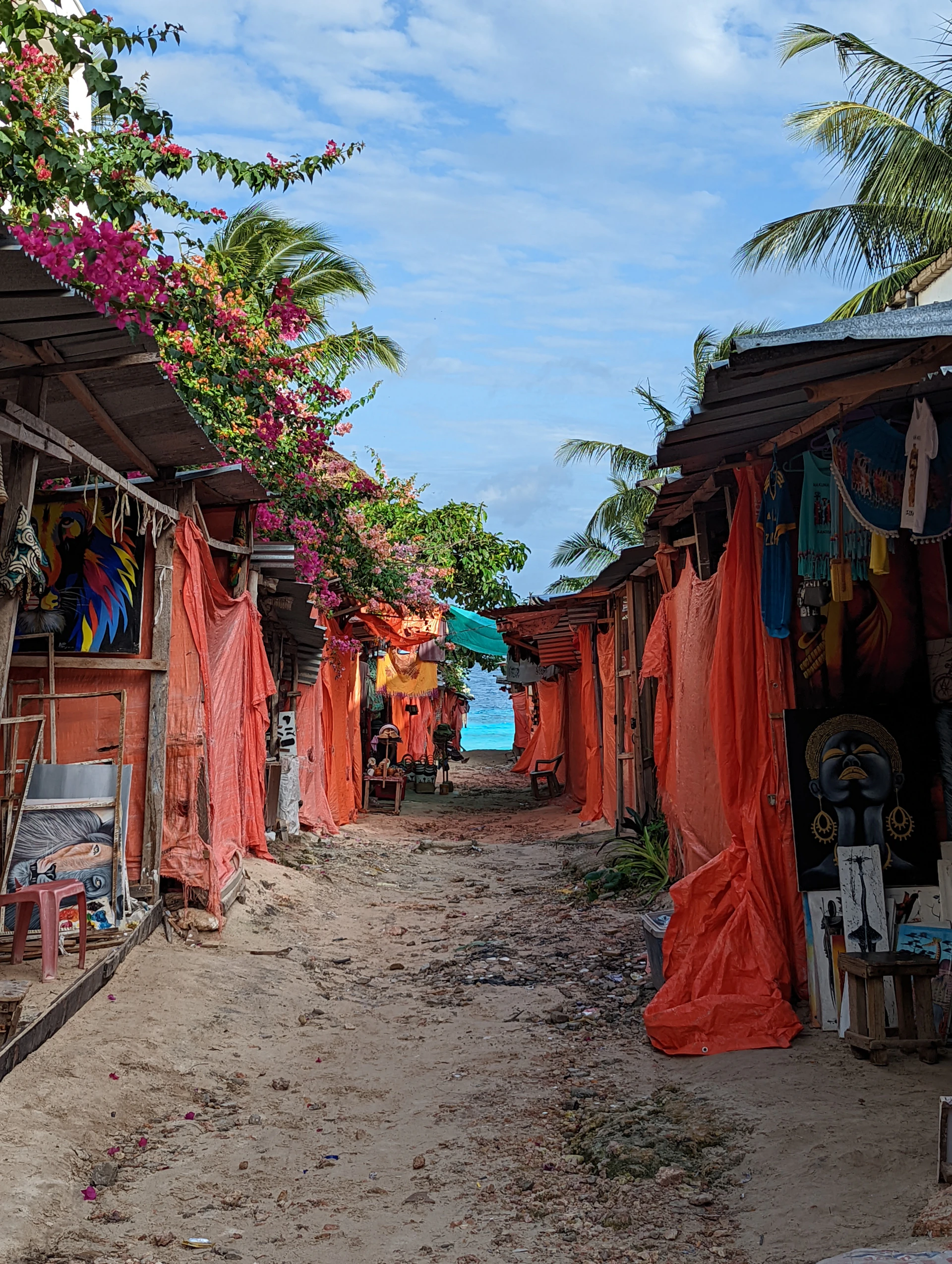 A lively street market in a coastal village, filled with colorful local crafts and smiling faces.