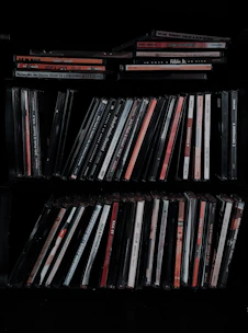 A vibrant display of colorful music CDs stacked in a cozy wooden shelf