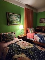 Family suite bedroom with two beds and colorful curtains enhancing a welcoming atmosphere.