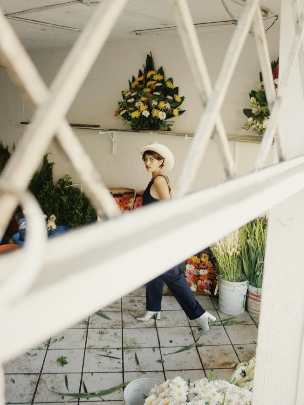 a woman in a white hat is seen through a window