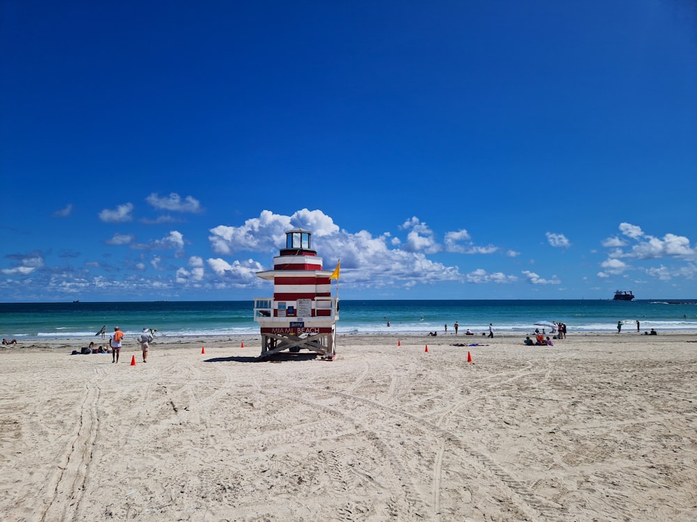 a lifeguard tower on a beach with people walking around