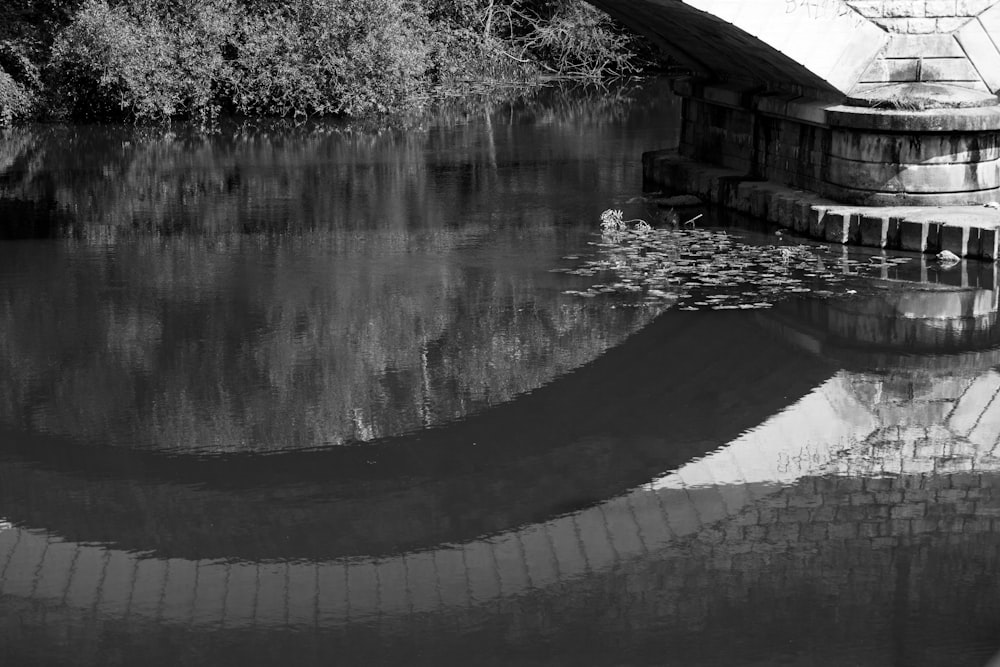 a black and white photo of a bridge over a river