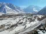 a snowy landscape with mountains in the background