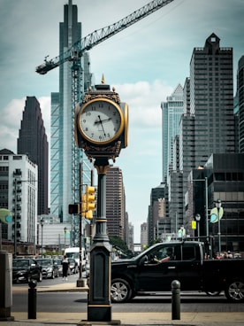 a clock on a pole in the middle of a city