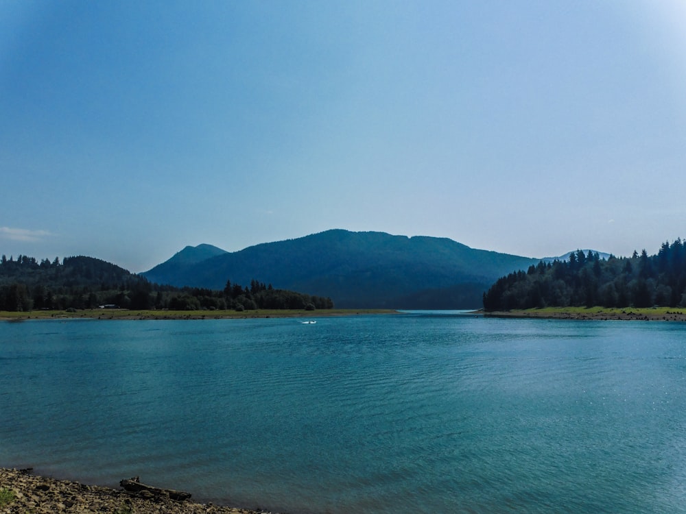 a body of water with mountains in the background