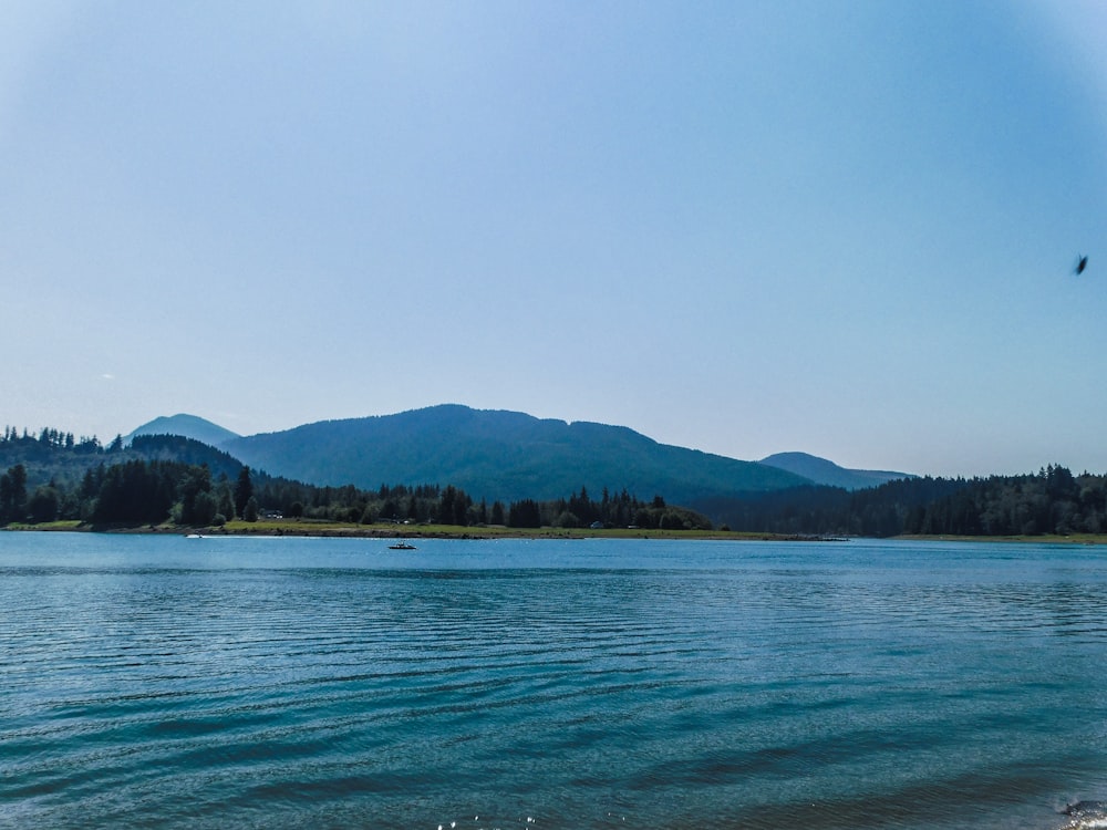 a body of water with mountains in the background