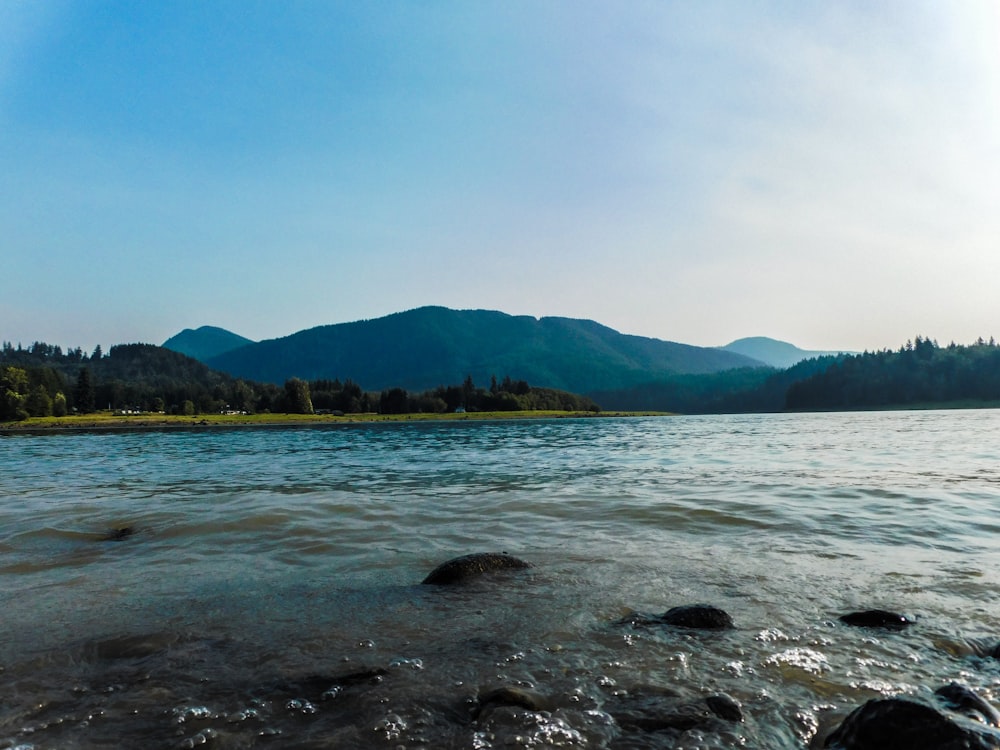 a body of water with mountains in the background