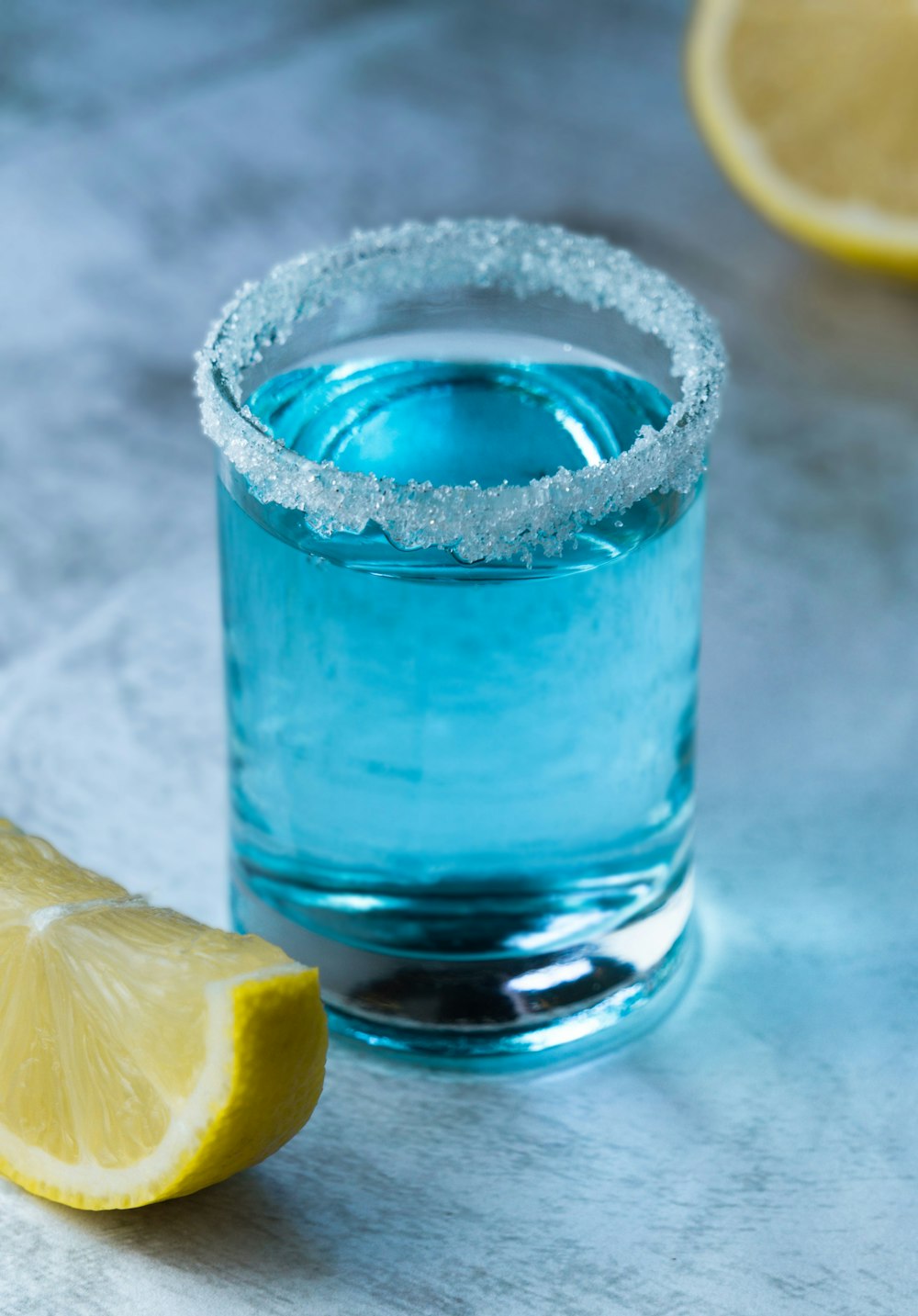 a glass of water with a slice of lemon next to it