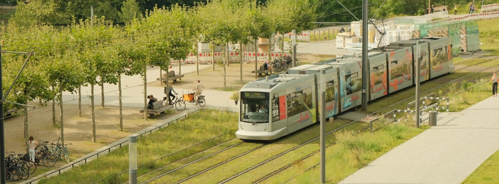 a train traveling down train tracks next to a forest