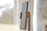 A close-up of a minimalist stabiliq phone stand holding a smartphone on a wooden desk with soft natural light.