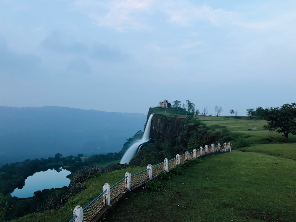 a large body of water sitting on top of a lush green hillside