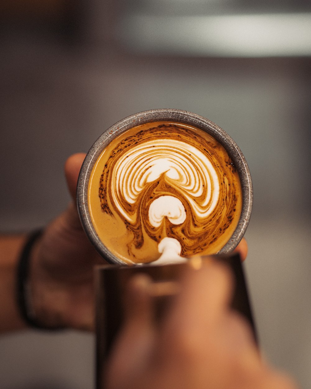 a person holding a cup of coffee in their hand