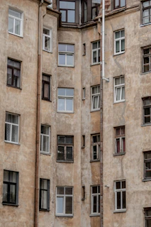 Wide shot of a weathered apartment building with faded and cracked exterior paint.