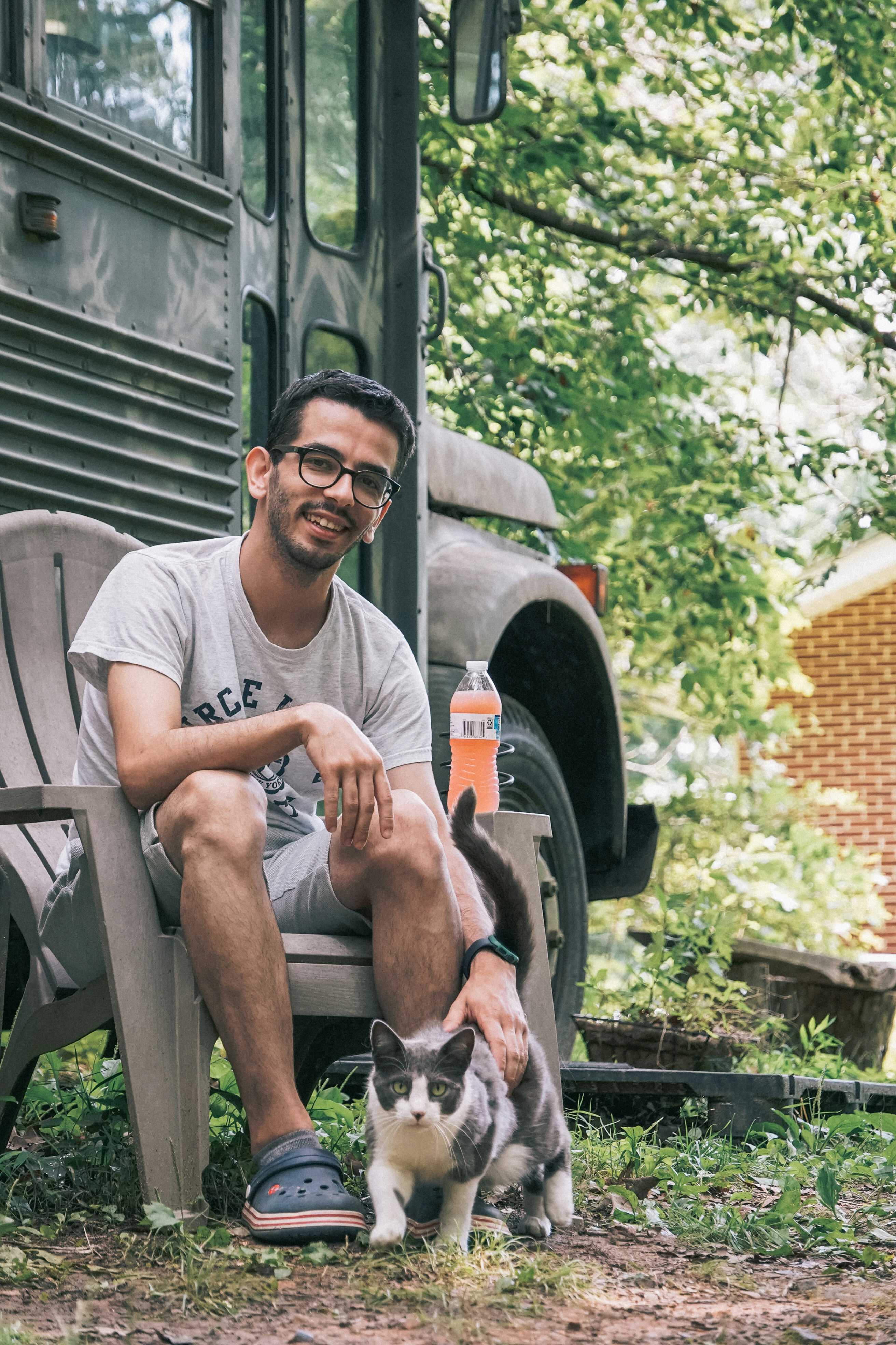 a man sitting on a bench next to a cat